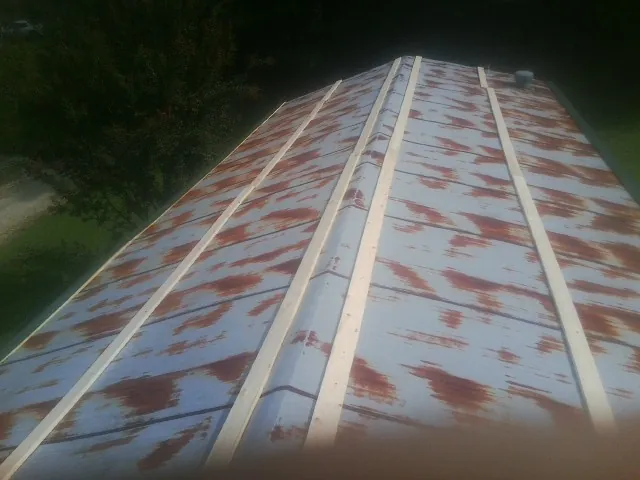 Rusted metal roof panels with new wood purlins before replacement — Storm Damage Roof Repair in Thief River Falls by Roofing Brothers