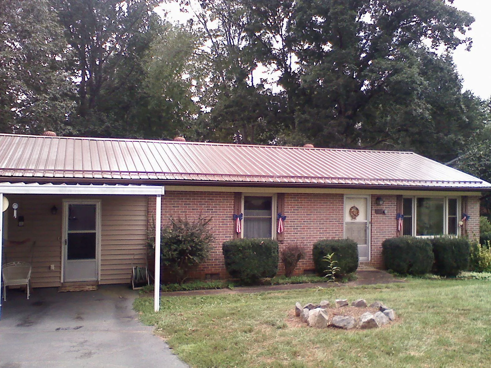 Bronze metal roof and carport on a brick ranch home — Roof Repair work by our crew in Thief River Falls